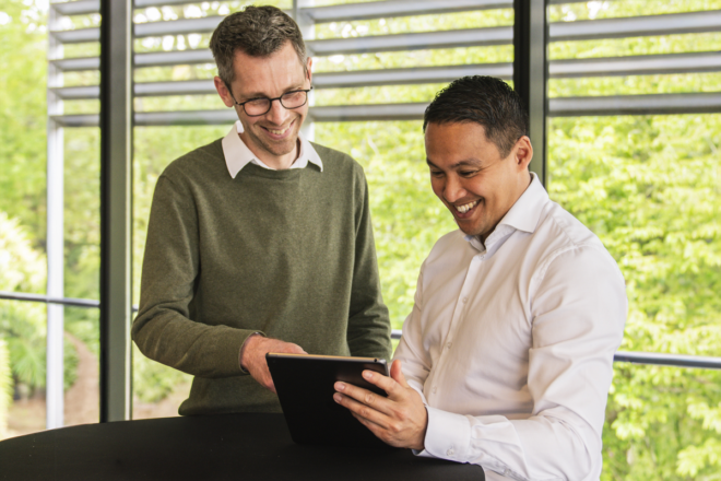 Twee medewerkers bekijken samen gegevens in een softwareapplicatie op tablet